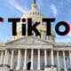 Logo of TikTok superimposed on the United States Capitol Building under a clear blue sky.